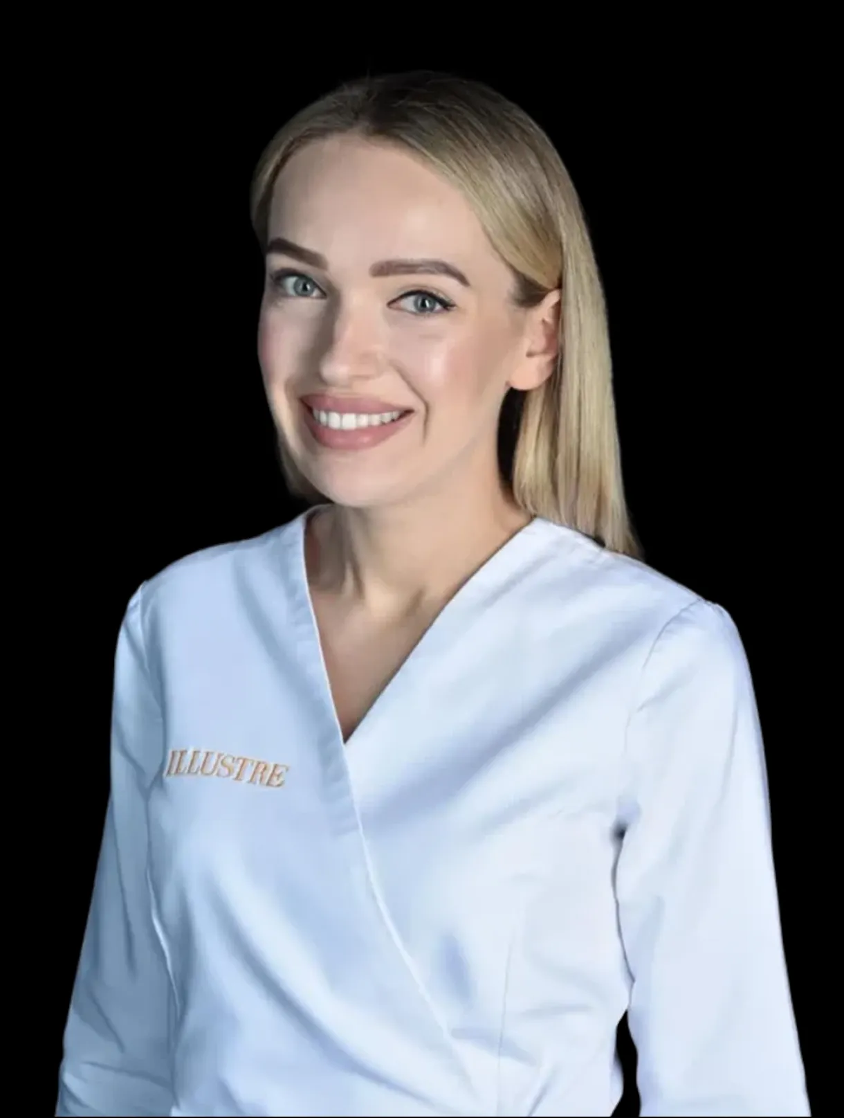 Kobieta o długich blond włosach ubrana w biały strój medyczny lub spa z haftem ILLUSTRE w kolorze złotym, uśmiechająca się na jednolitym czarnym tle - reprezentująca usługi medycyny estetycznej Wrocław i expert botoks Wrocław.
